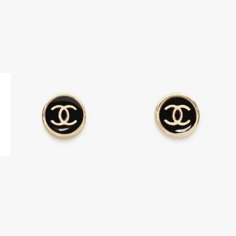 Pair of Chanel earrings with black and gold logo on a white background