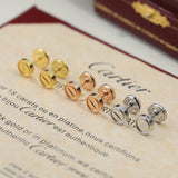 Set of Cartier earrings on a piece of paper with text