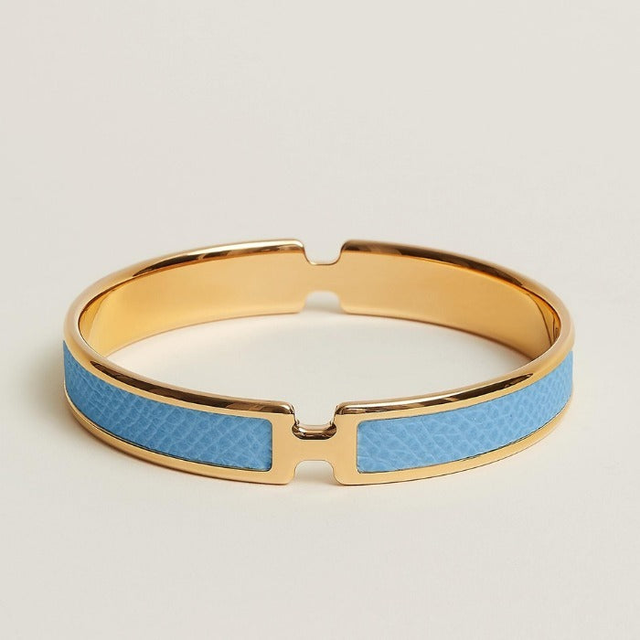 Gold and blue bracelet on a light beige background