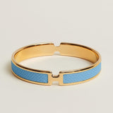 Gold and blue bracelet on a light beige background